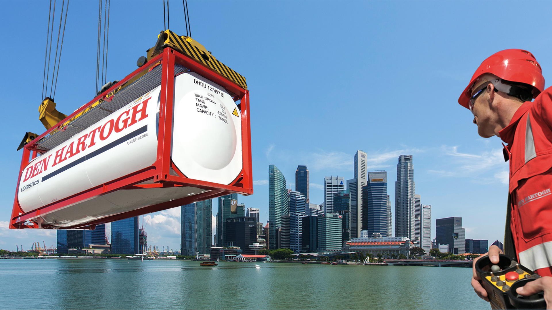 A truck container being lifted by ropes with skyscrapers in the background