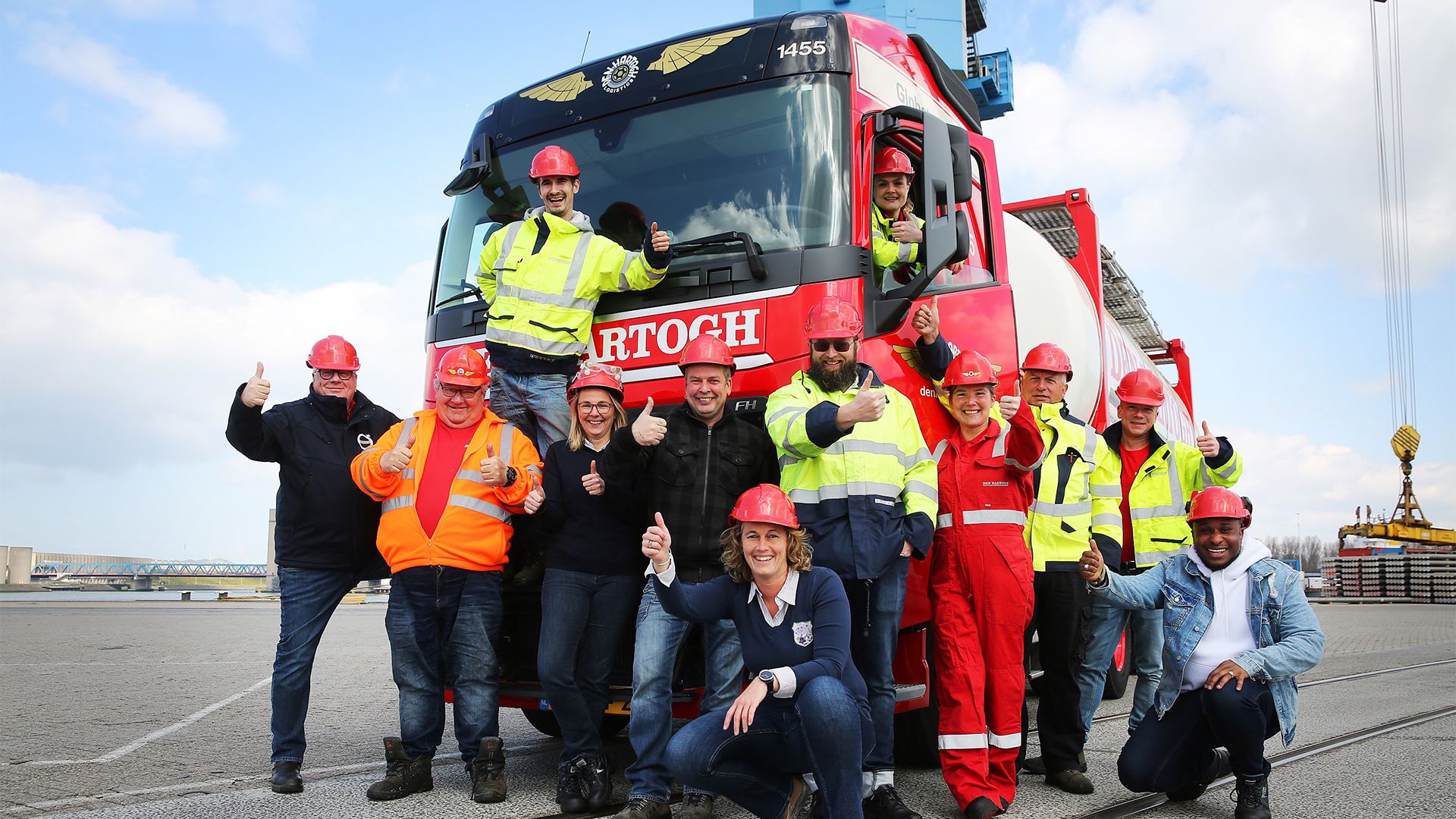 A group of truck drivers posing in front of a truck