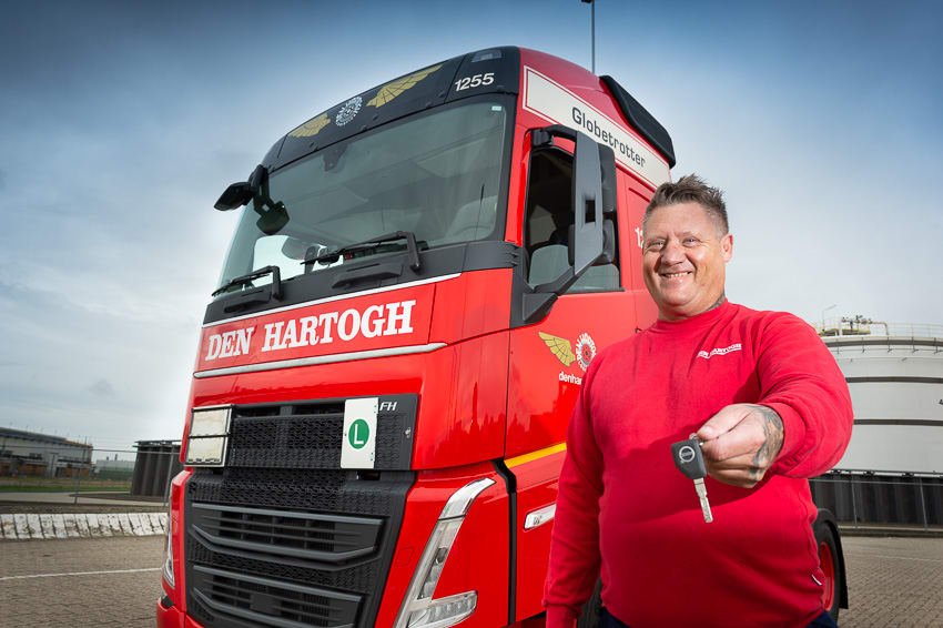 Man standing in front of a truck with the key and smiling