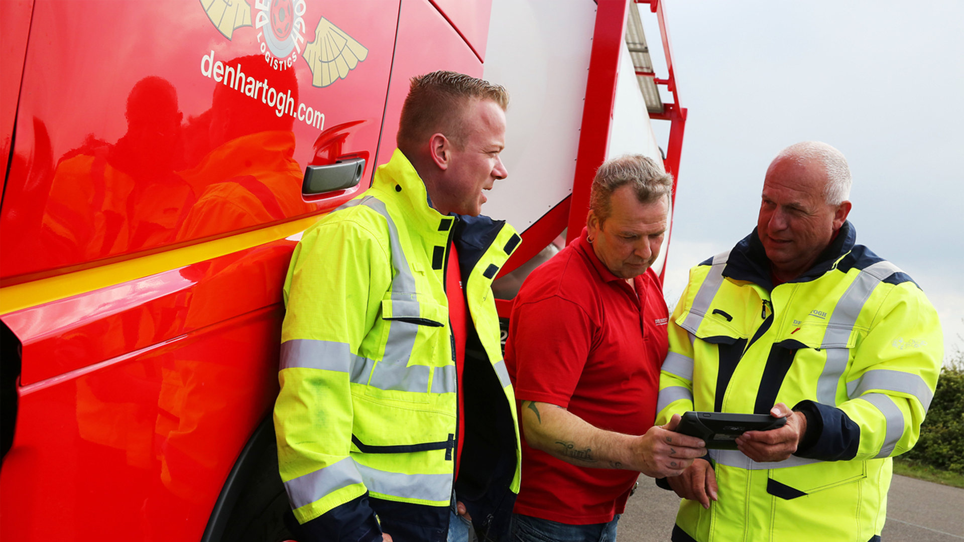 A group of truck drivers posing in front of a truck