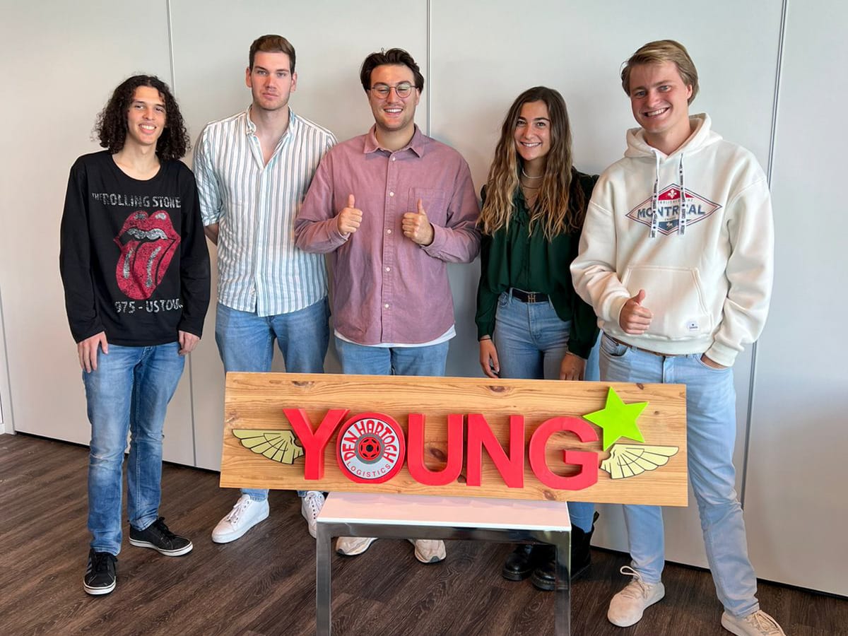 A group of young people posing in front of a sign reading 'YOUNG'