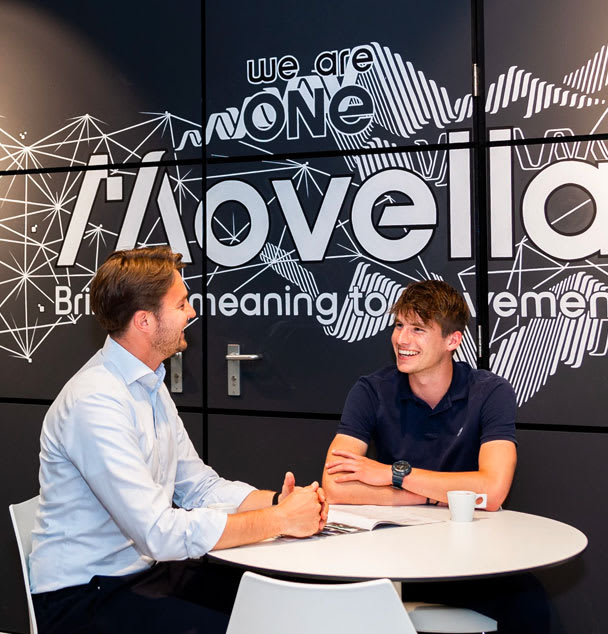 Two people talking at a desk