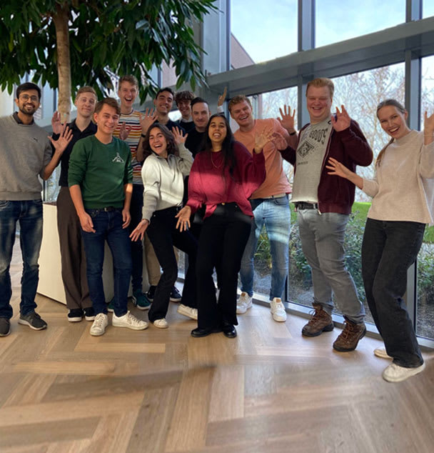 Interns in front of a tree and window