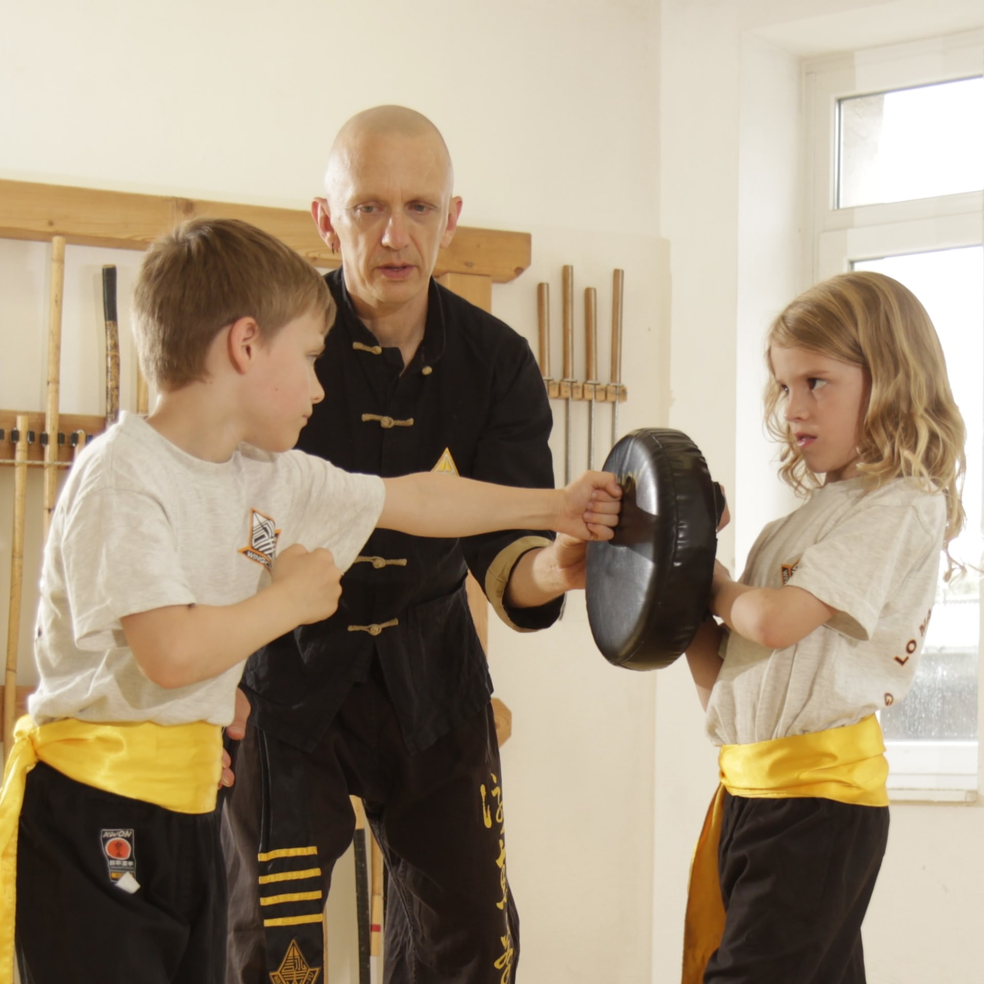 Kung Fu Trainer hilft Kindern beim richtigen Schlagtraining 