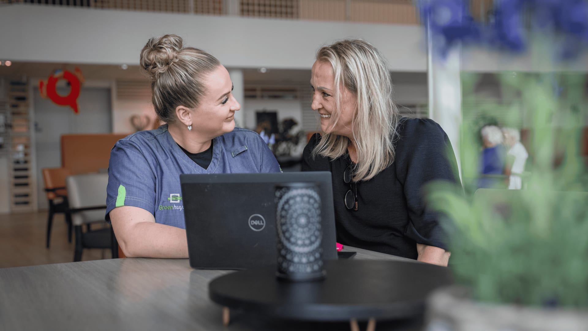 Teamcoördinator in gesprek met een zorgcollega