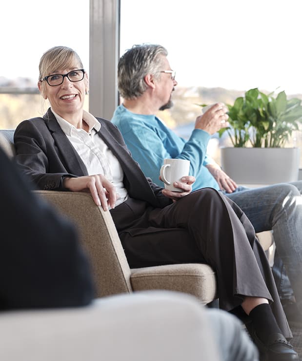 Eine Kollegin und ein Kollege verbringen die Pause sitzend im Lounge-Bereich von ECON TEL.
