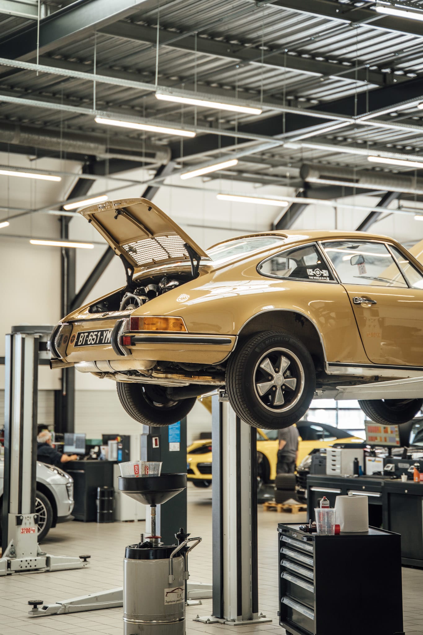 Porsche classique sur pont élévateur dans un atelier des Centres Porsche RCM