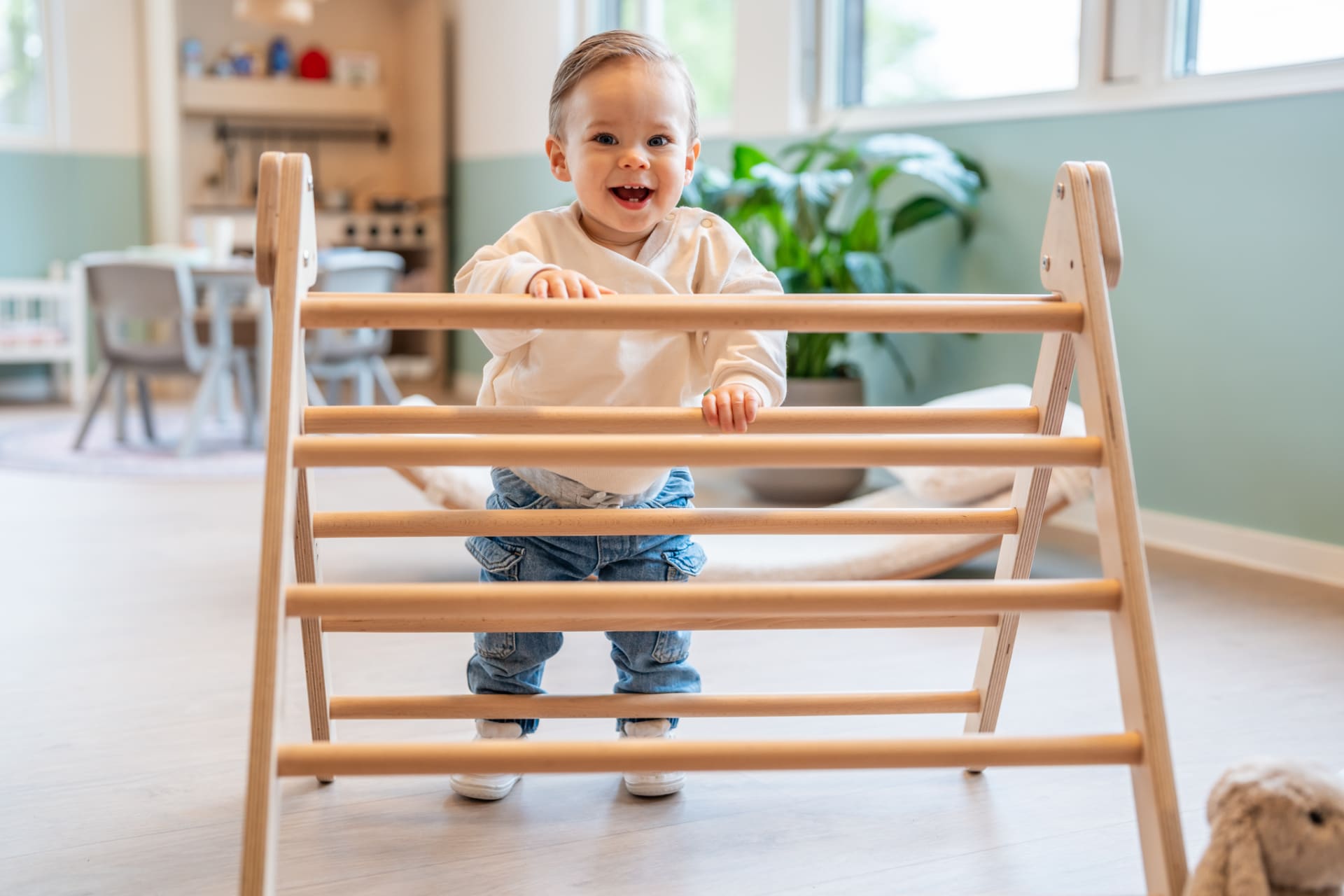 KION-kleuter-staat-lachend-tegen-klimrek