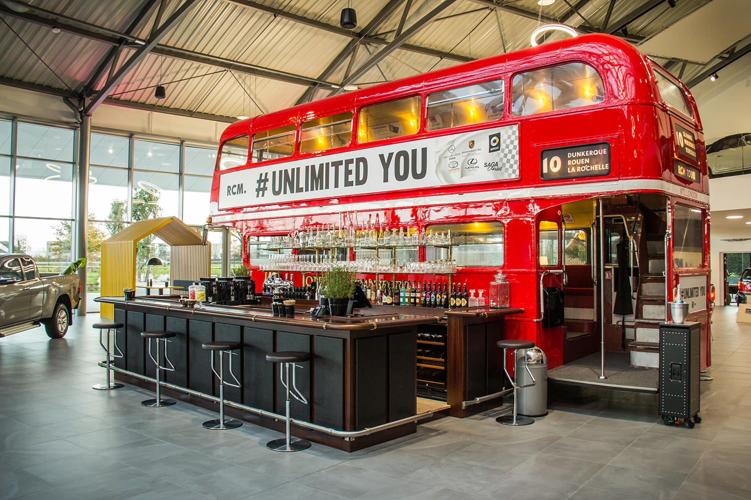Showroom RCM s červeným autobusem a odpočinkovou zónou