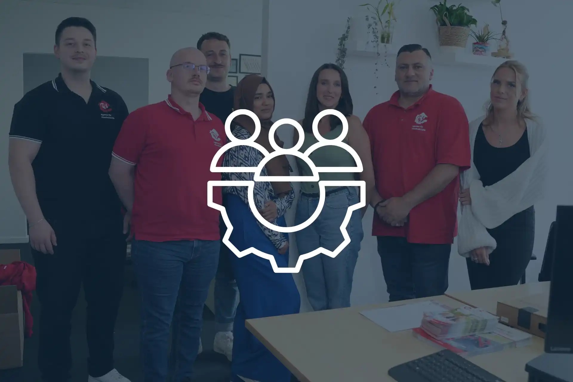 Mehrere Mitarbeiter der Abteilung Teamkoordination Innendienst stehen für ein Teamfoto beisammen und lächeln in die Kamera