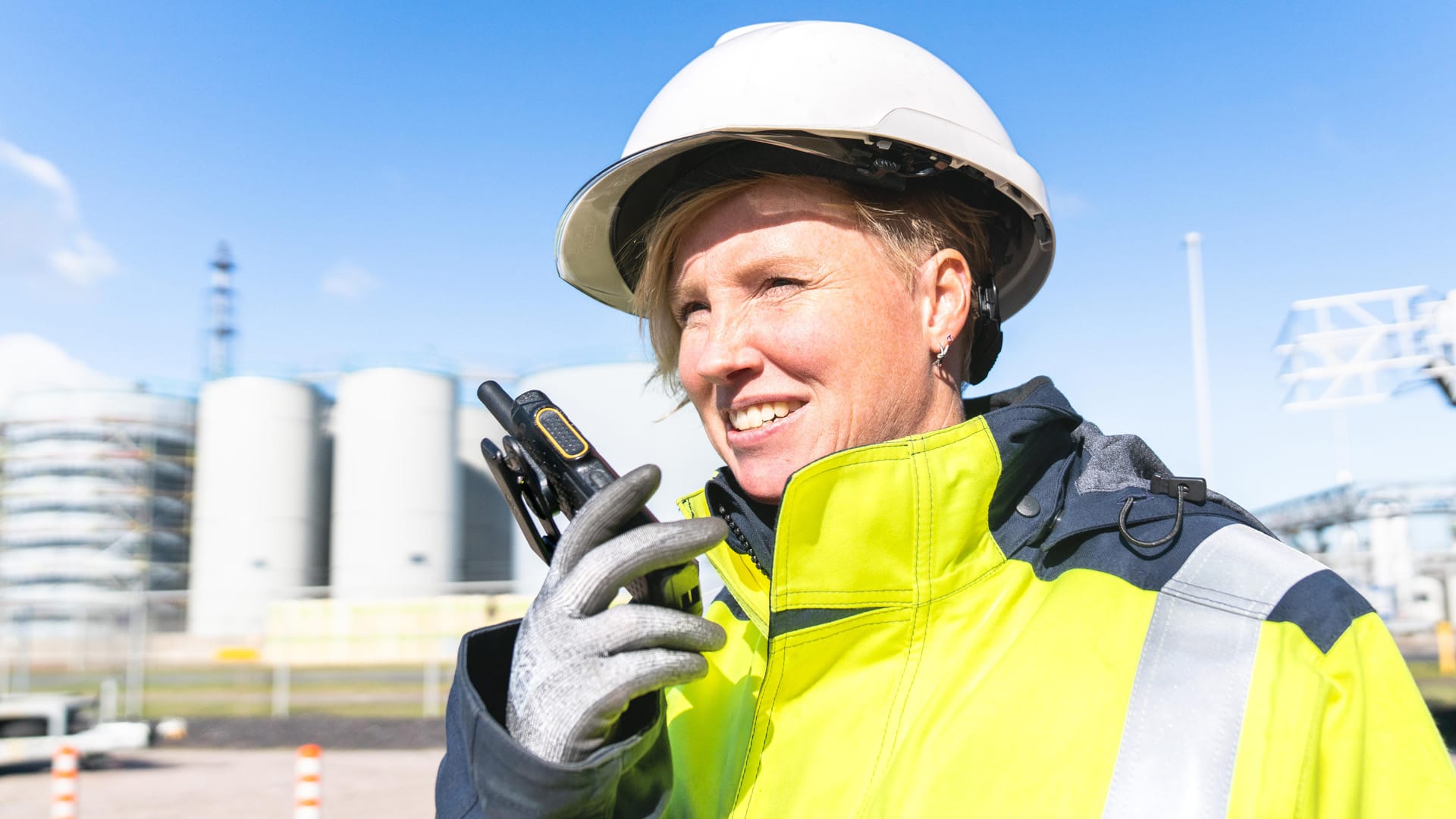 Women holding walkietalkie, standing in industry area