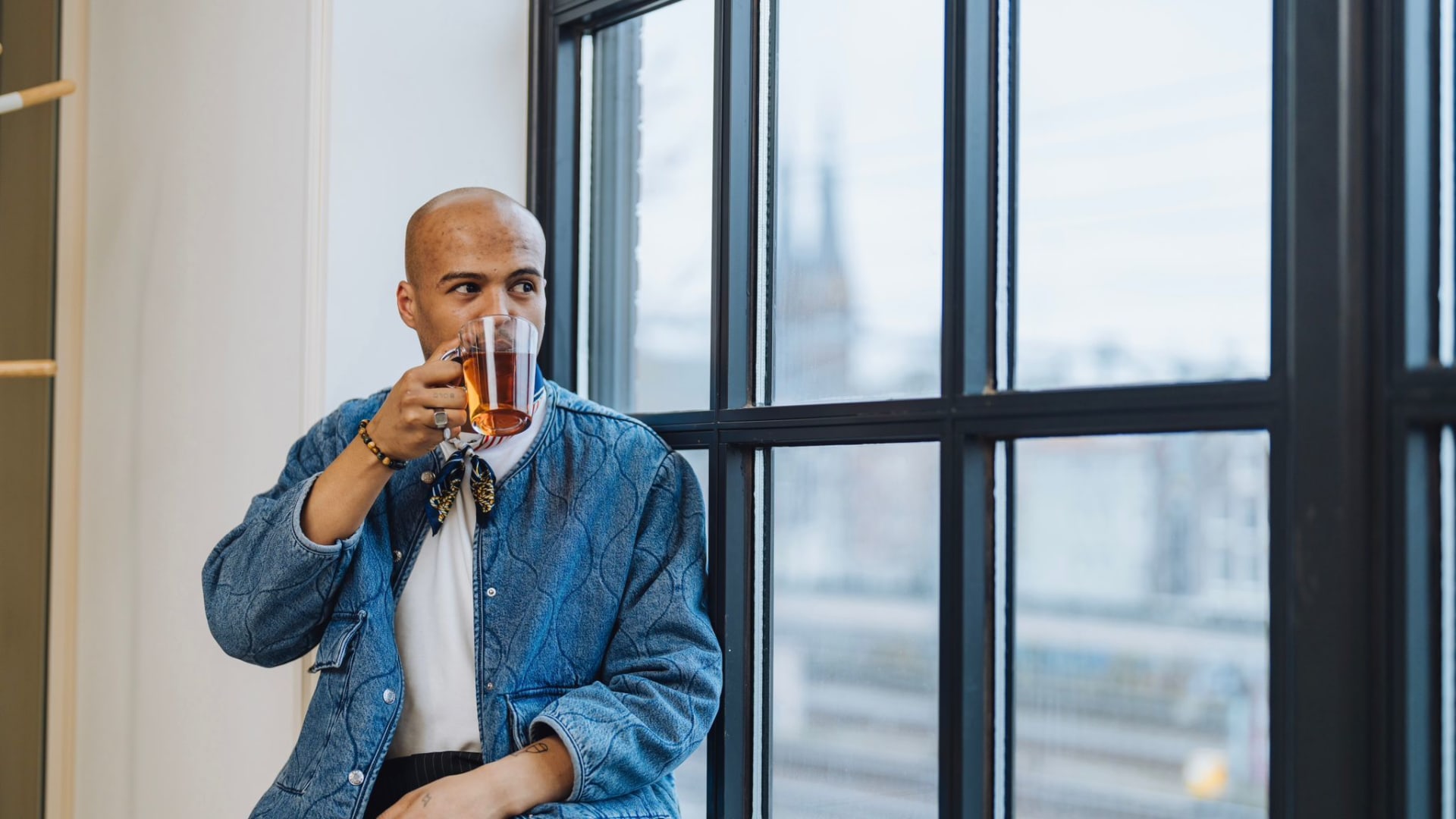 Employee enjoys cup of tea while looking outside 