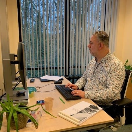 Ronald aan het werk aan zijn bureau