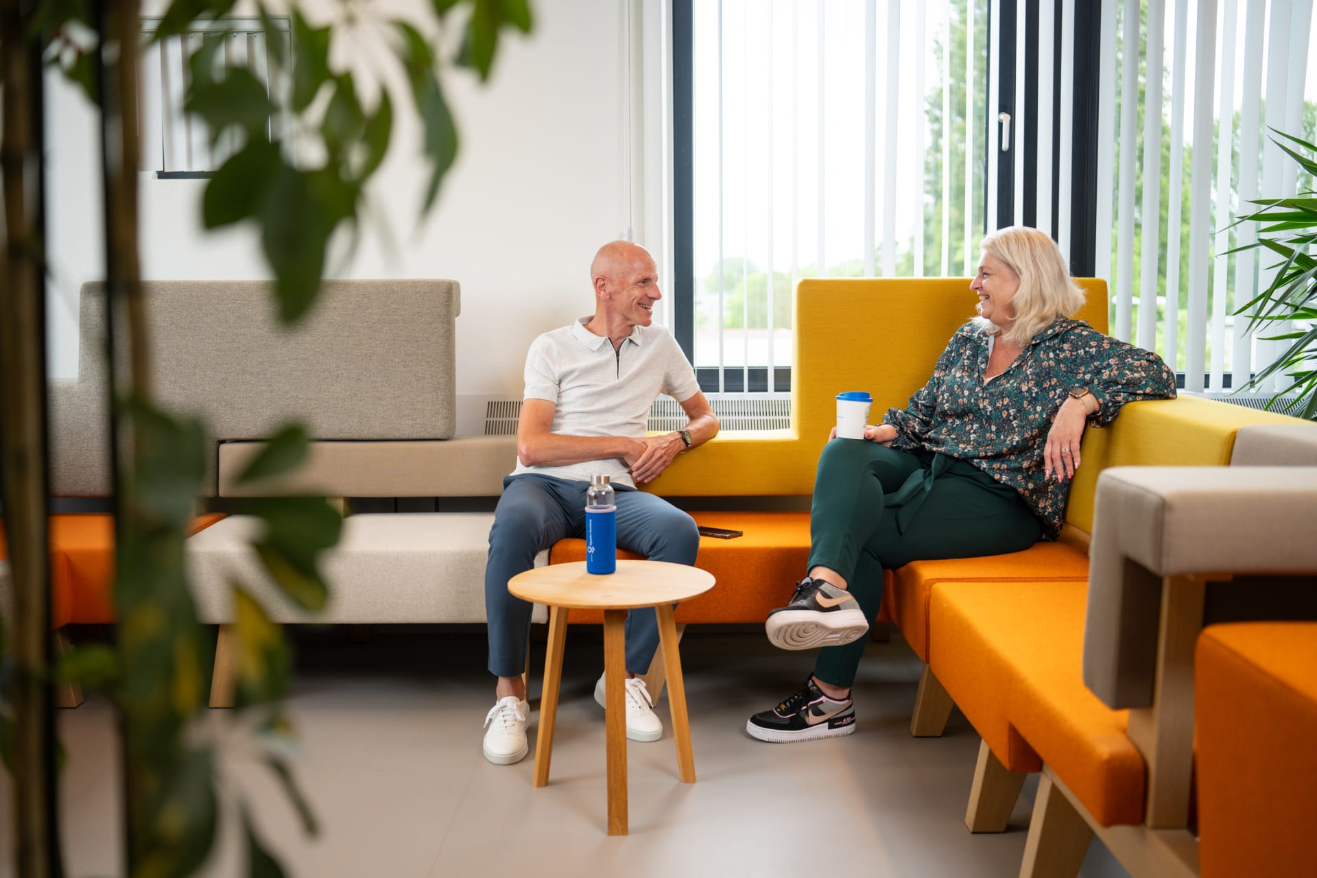 Twee collega's aan het praten op een hoekbank