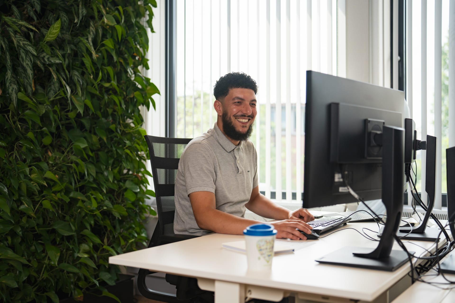 Collega glimlachend achter computerscherm