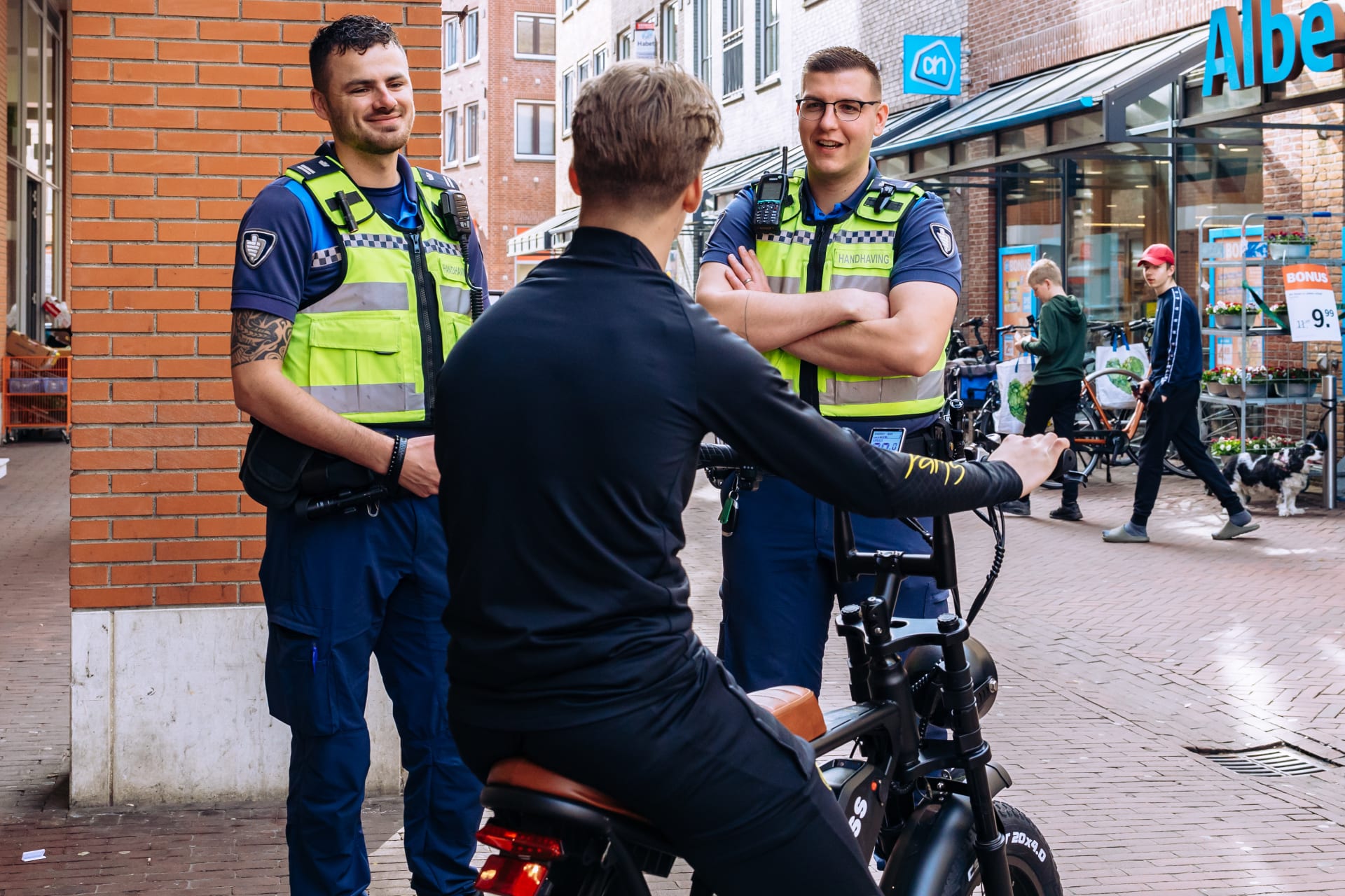 Twee wijkagenten die een gesprek hebben met een jongen op een fatbike
