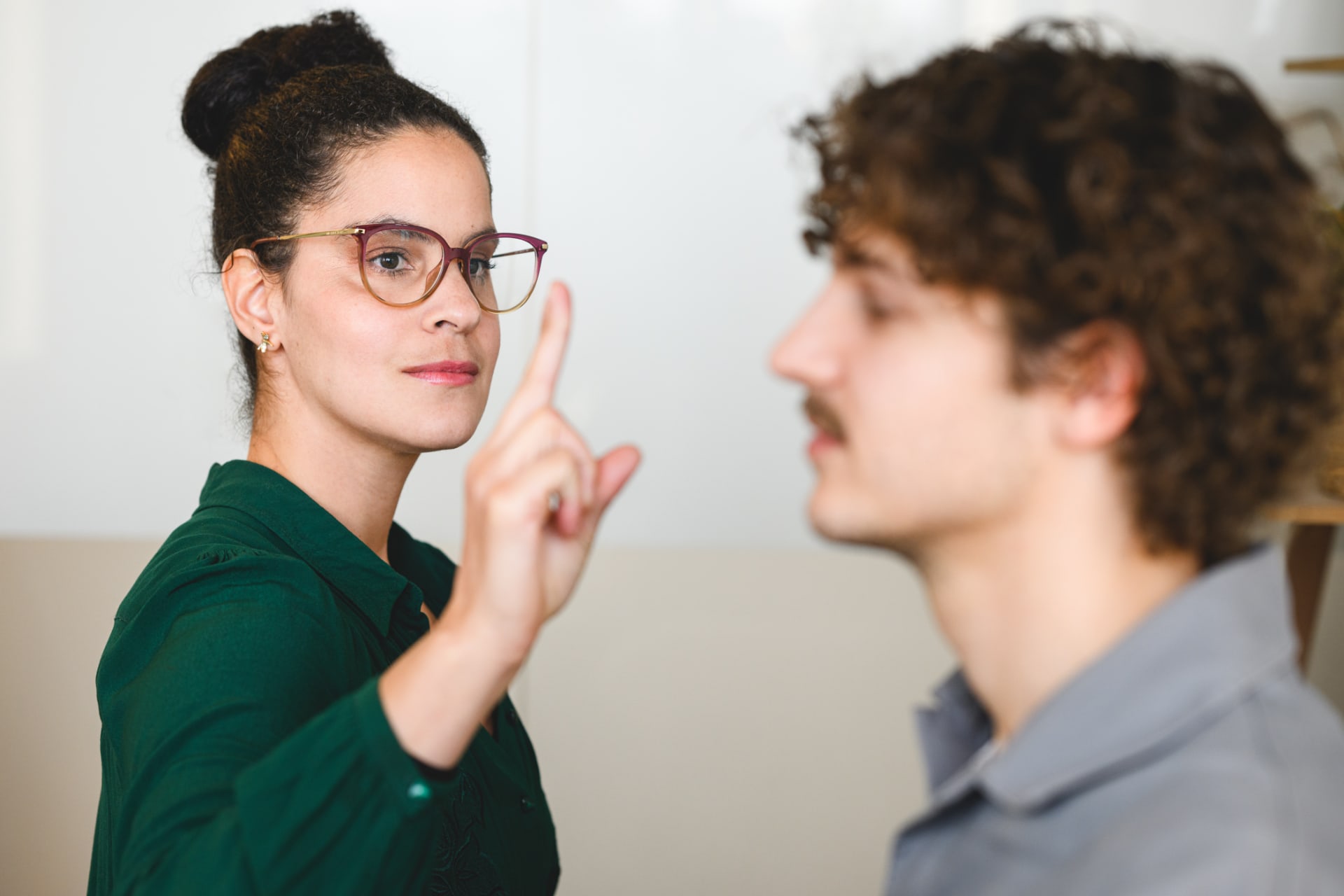 Vrouw met bril en knot, met hand voor de ogen van de mannelijke cliënt, tijdens een EMDR-sessie