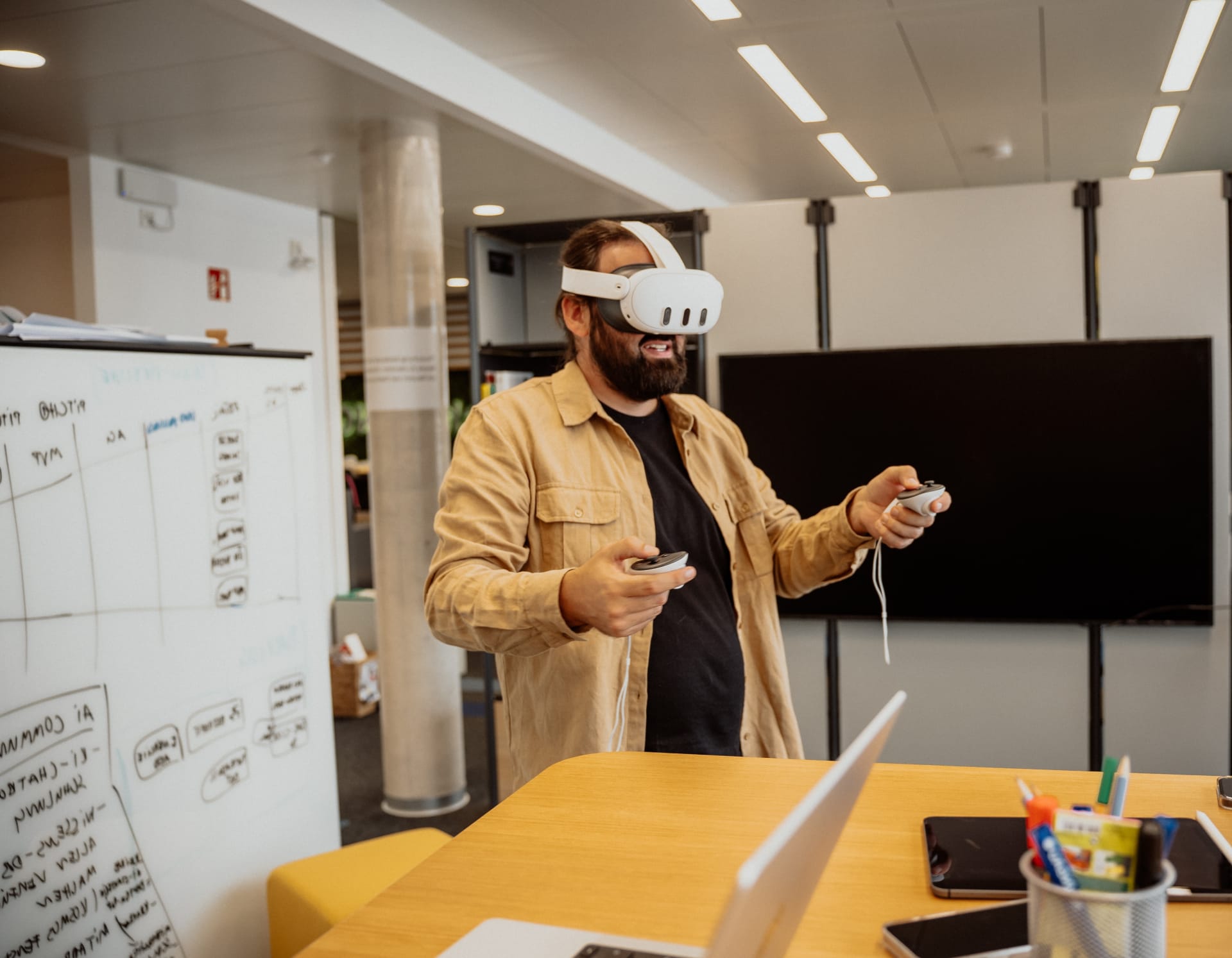 Eine Person mit einer VR-Brille auf dem Kopf und Controllern in der Hand.