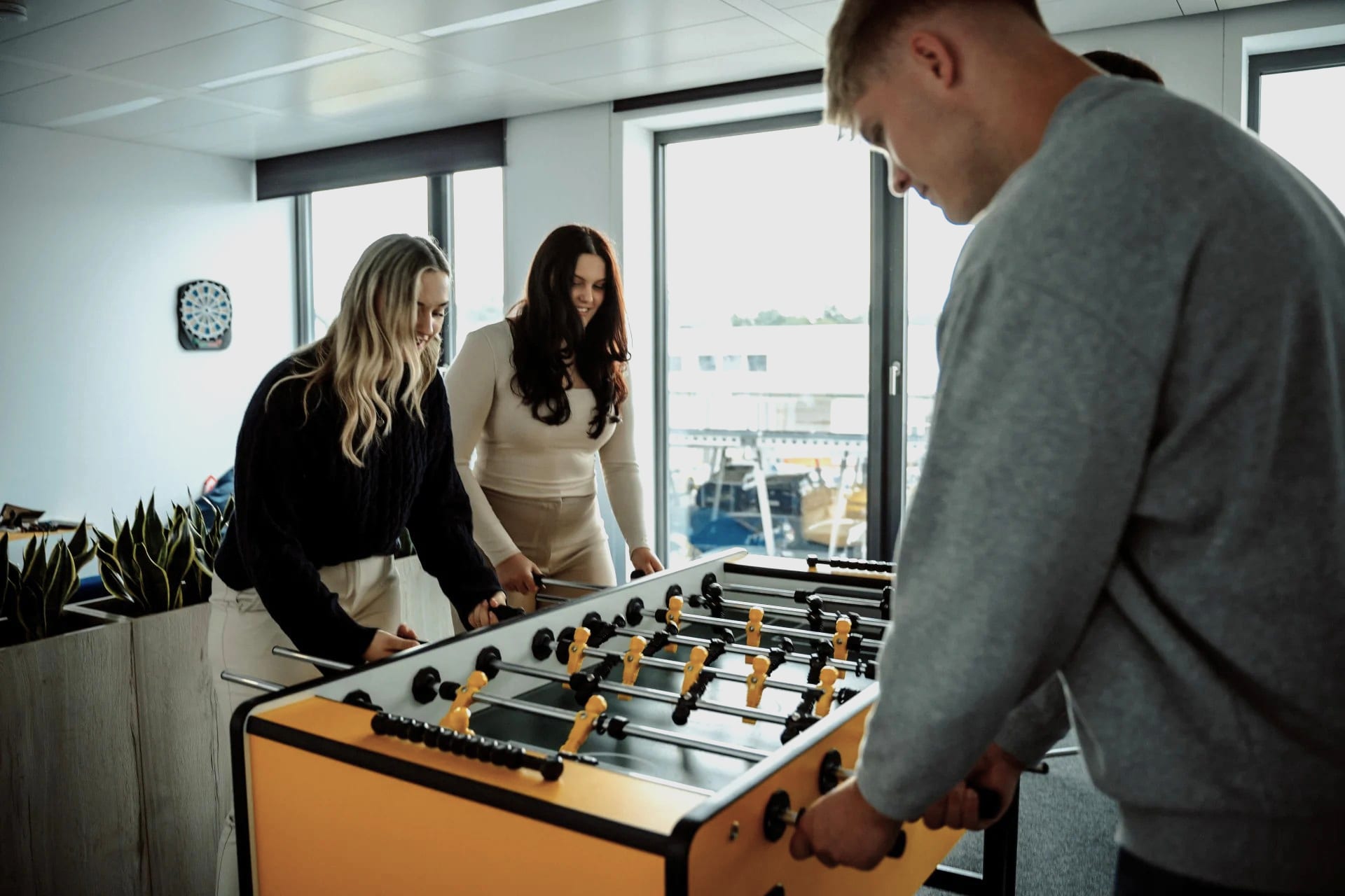 Eine vierer Gruppe Nachwuchskräfte beim Tischkickern