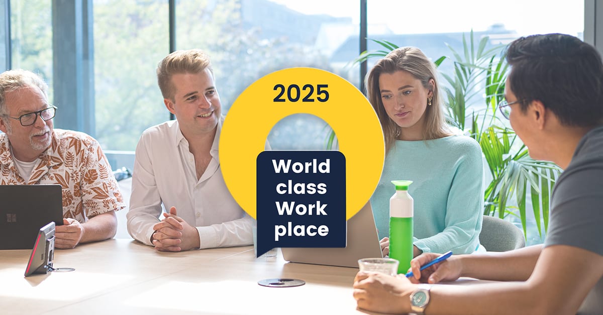 Beeld van collega's in overleg. In het midden het logo van World Class Work Place 2025
