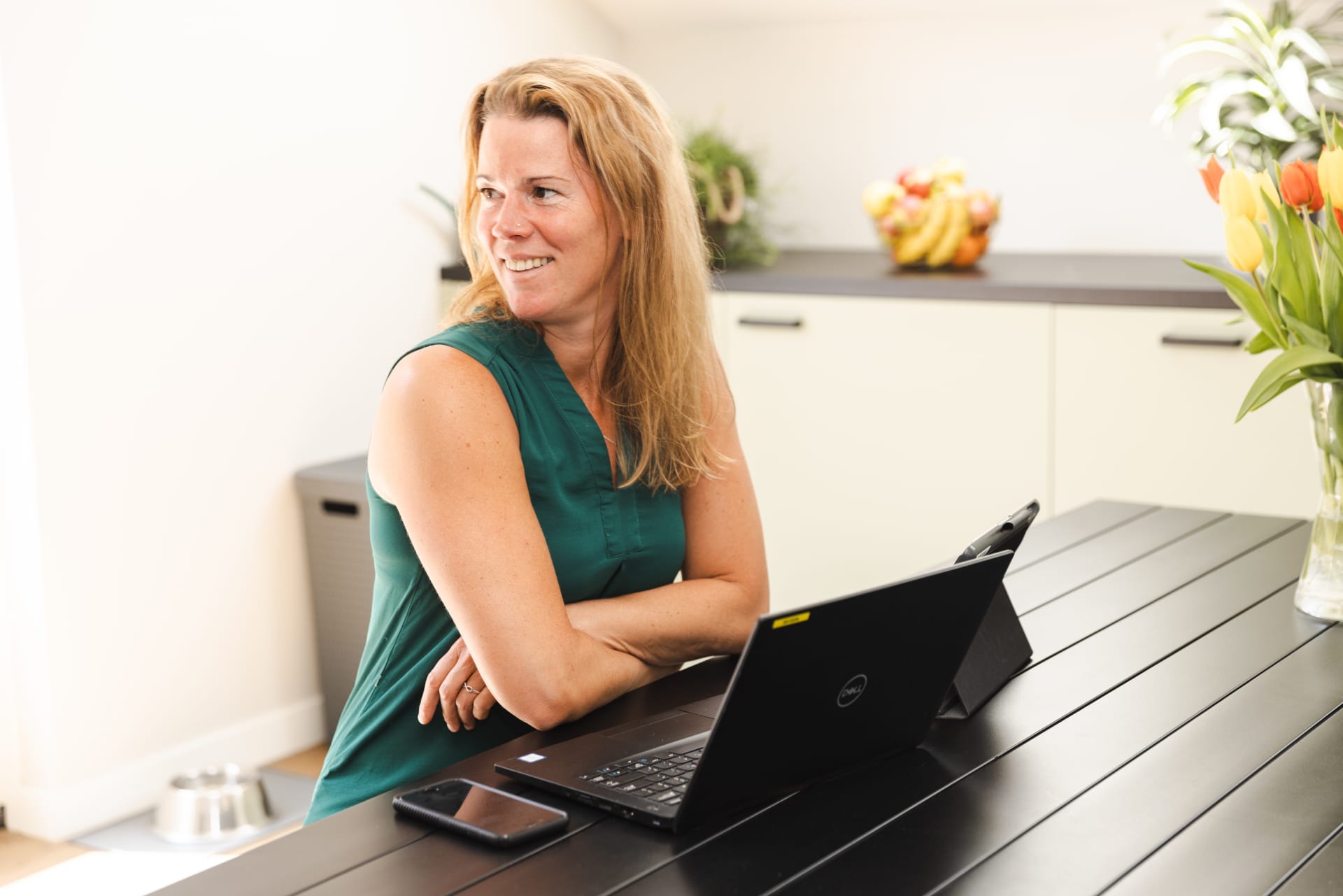 Coördinator huishoudelijke ondersteuning bij Poetszorg met een laptop