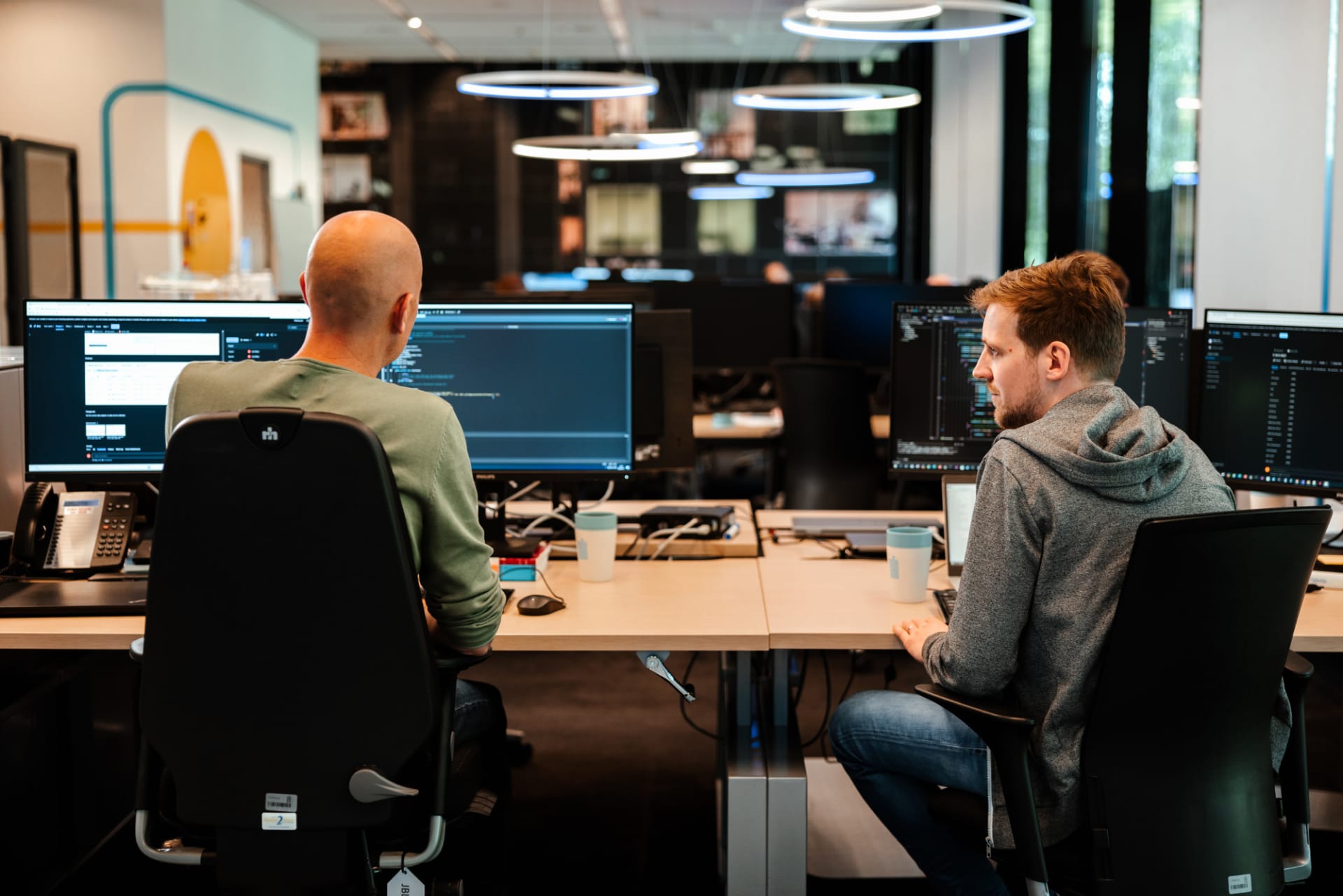 Collega's zitten beide achter de computer op kantoor