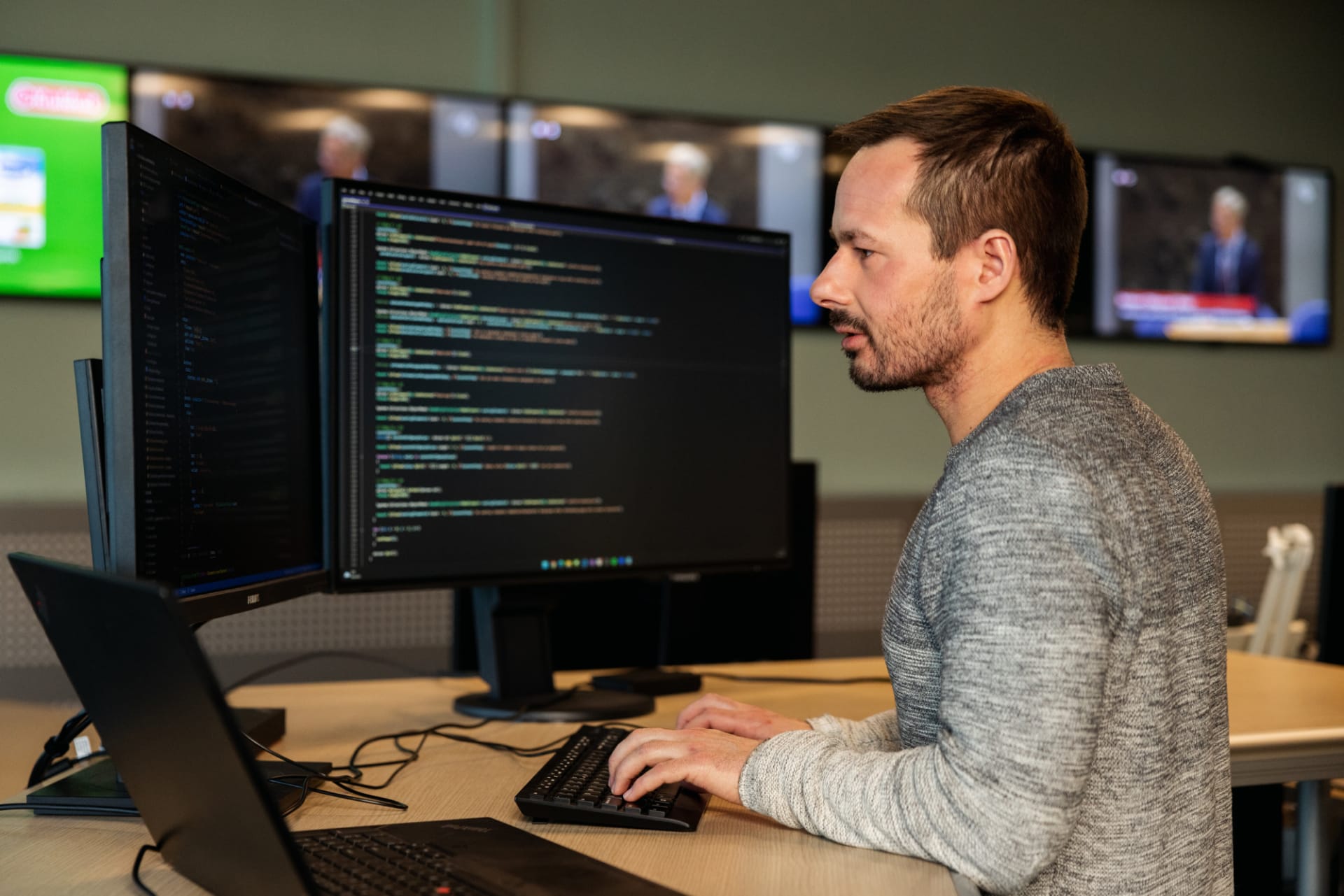 Collega werkt achter de computer met code