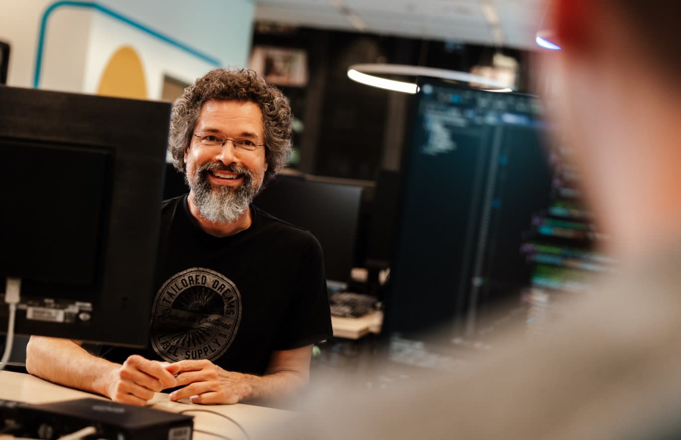 Collega glimlacht in de camera van achter bureau