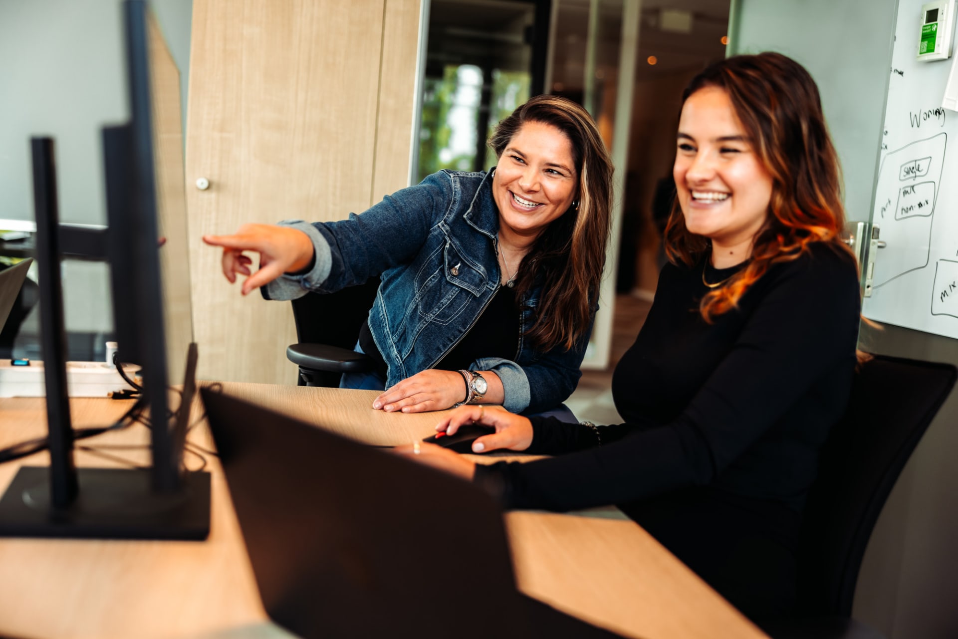 Collega's werken vrolijk samen achter computer
