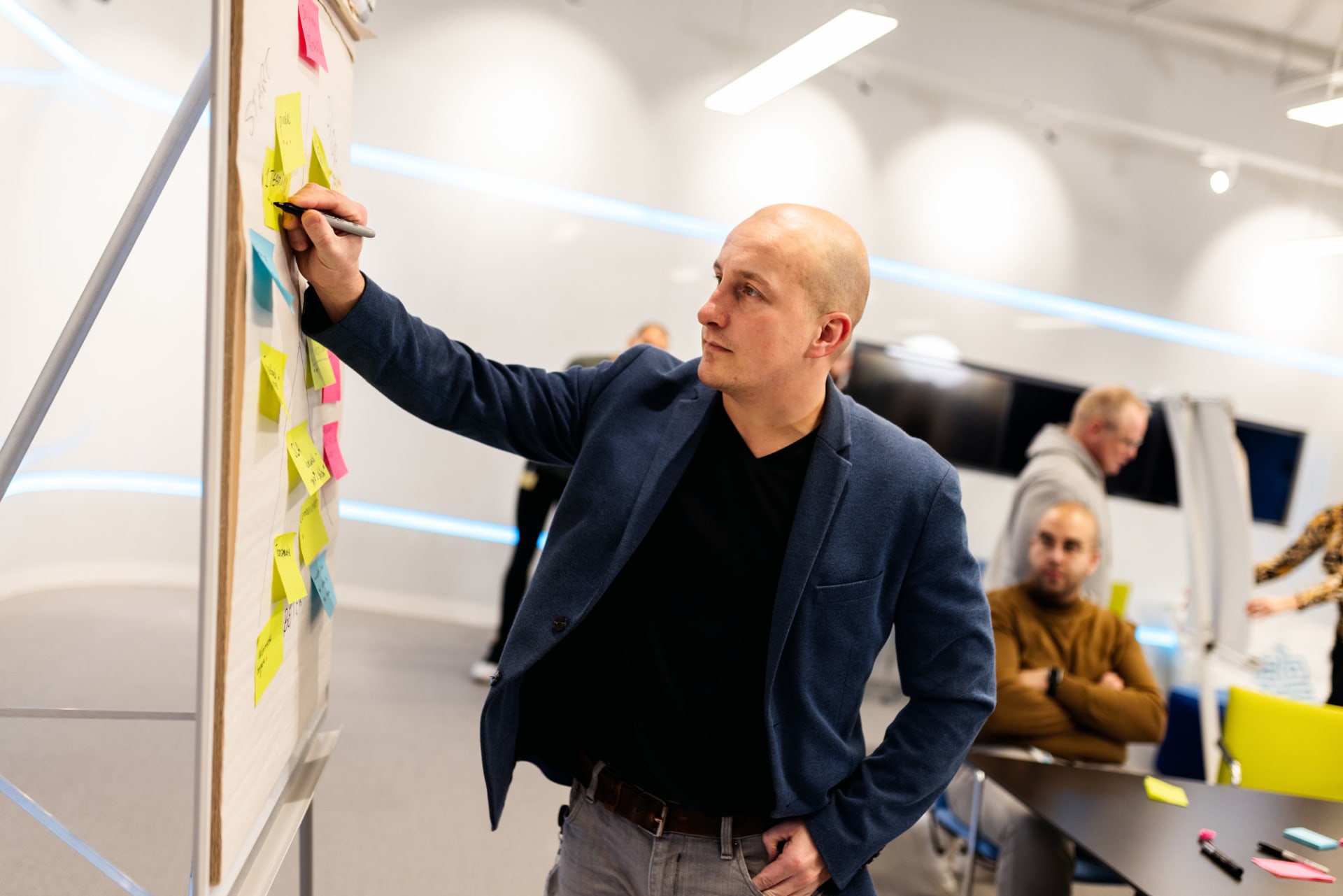Collega schrijft op whiteboard vol post-its