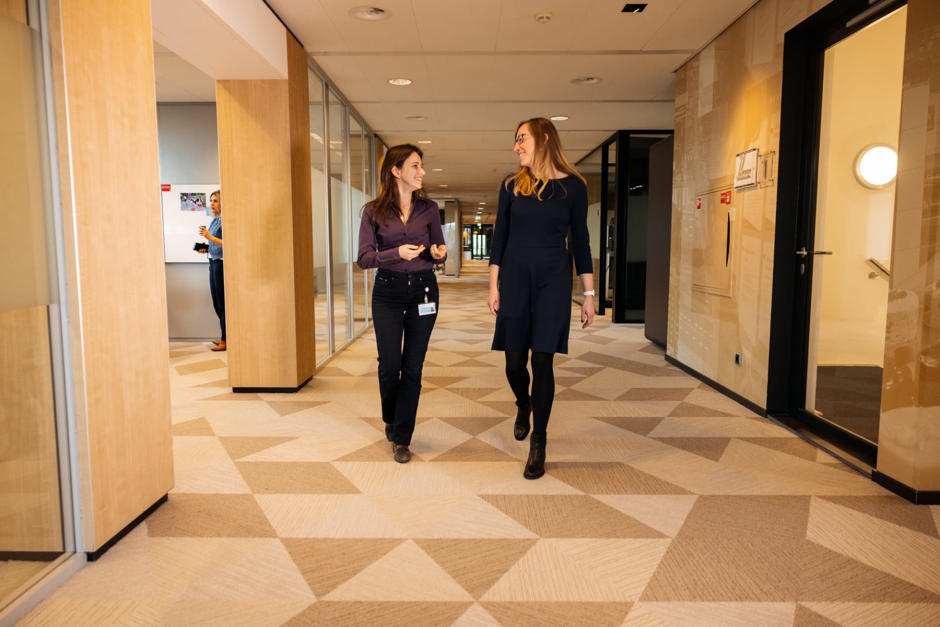 Twee collega's lopen door de gang op het CBS-kantoor