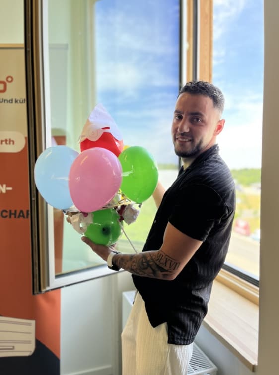 Albert mit Luftballons beim dekarbo Townhall im Teambuilding Spiel
