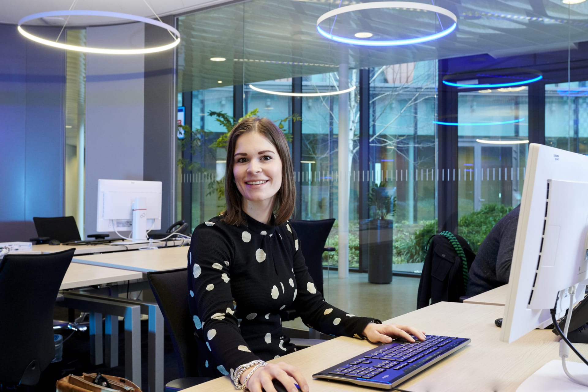 Kim zit lachend aan haar bureau