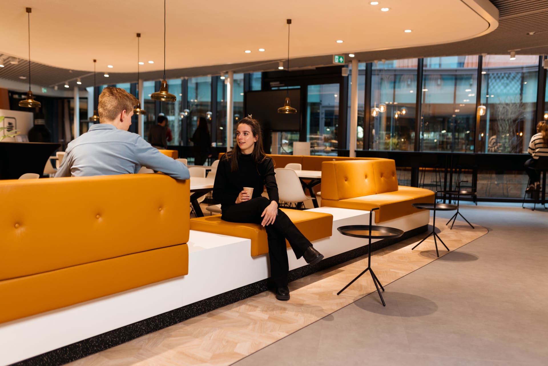 Twee collega's in het cafe van het kantoor Den Haag