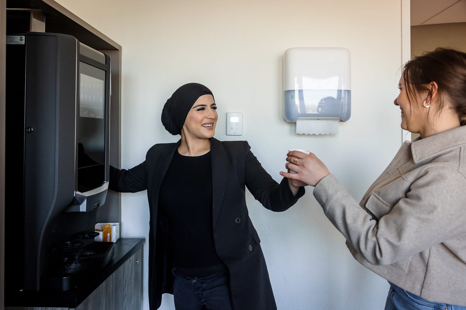 Twee collega's bij het koffieapparaat