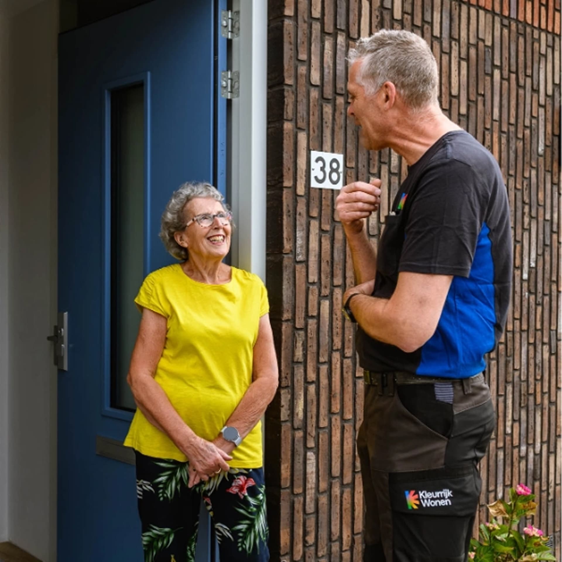 Een Kleurrijk Wonen collega praat met een bewoner