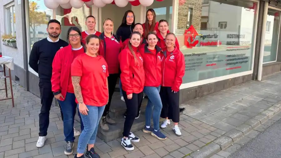 Group photo of several employees of the Agency for Household Help standing together at the office opening event in Mayen-Koblenz.