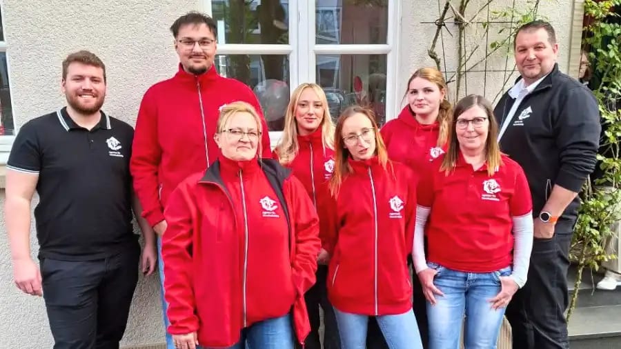 Group photo of employees of the Agency for Household Help at the office opening in Warendorf, standing together and celebrating the launch of the new location.