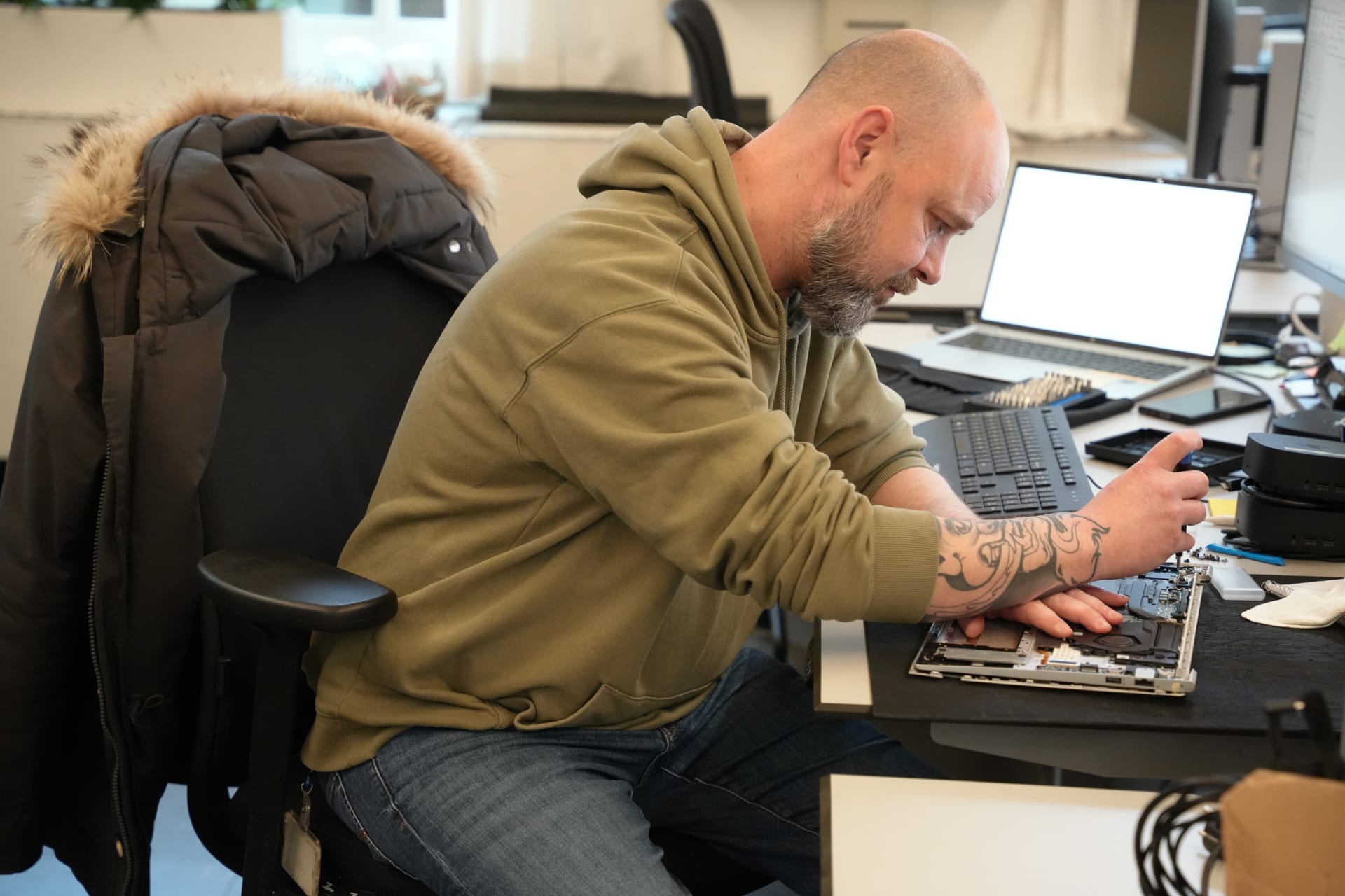 een medewerker servicedesk repareert een laptop