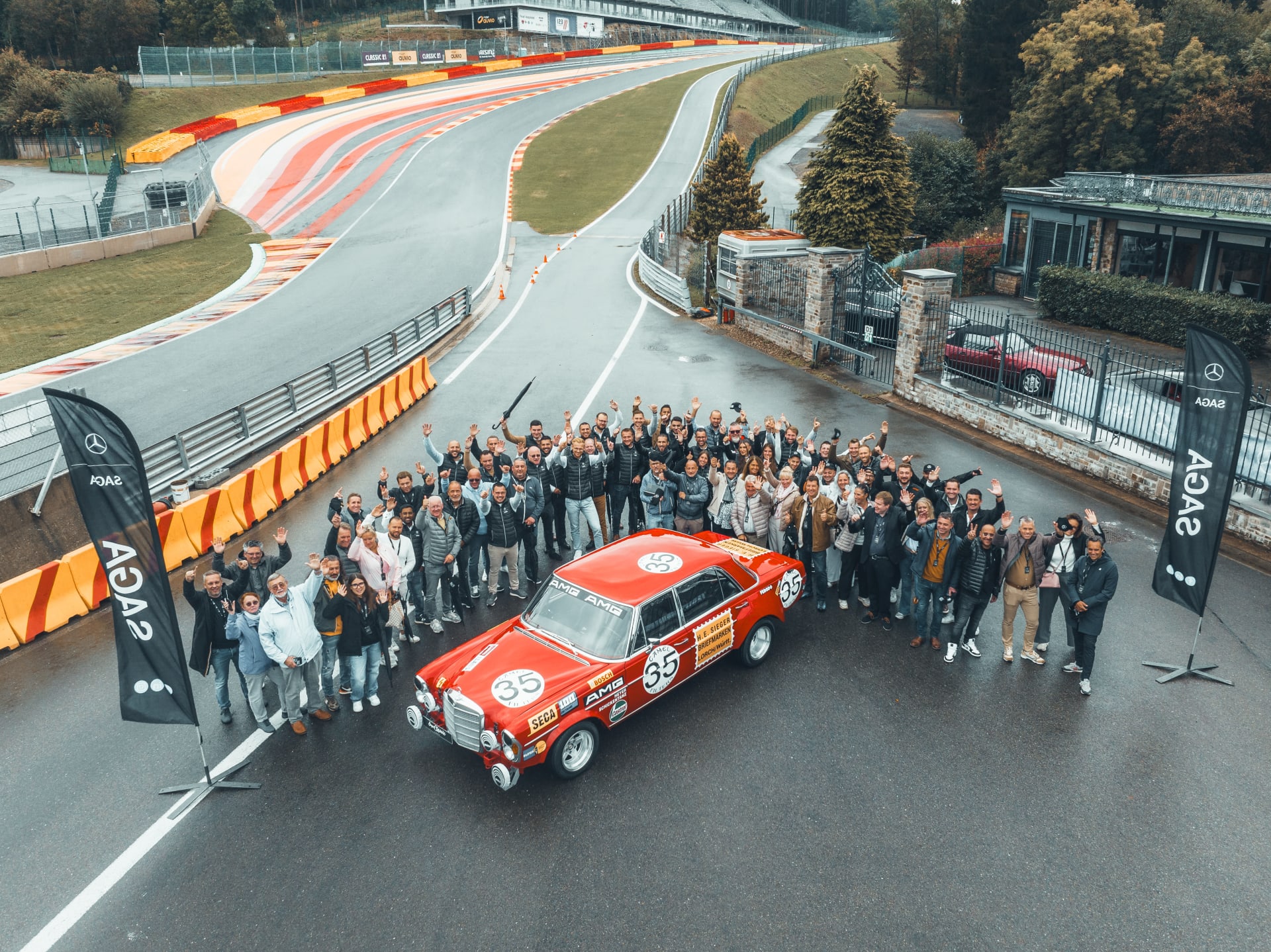 Équipe SAGA Belgique réunie autour d’une Mercedes-Benz classique sur circuit