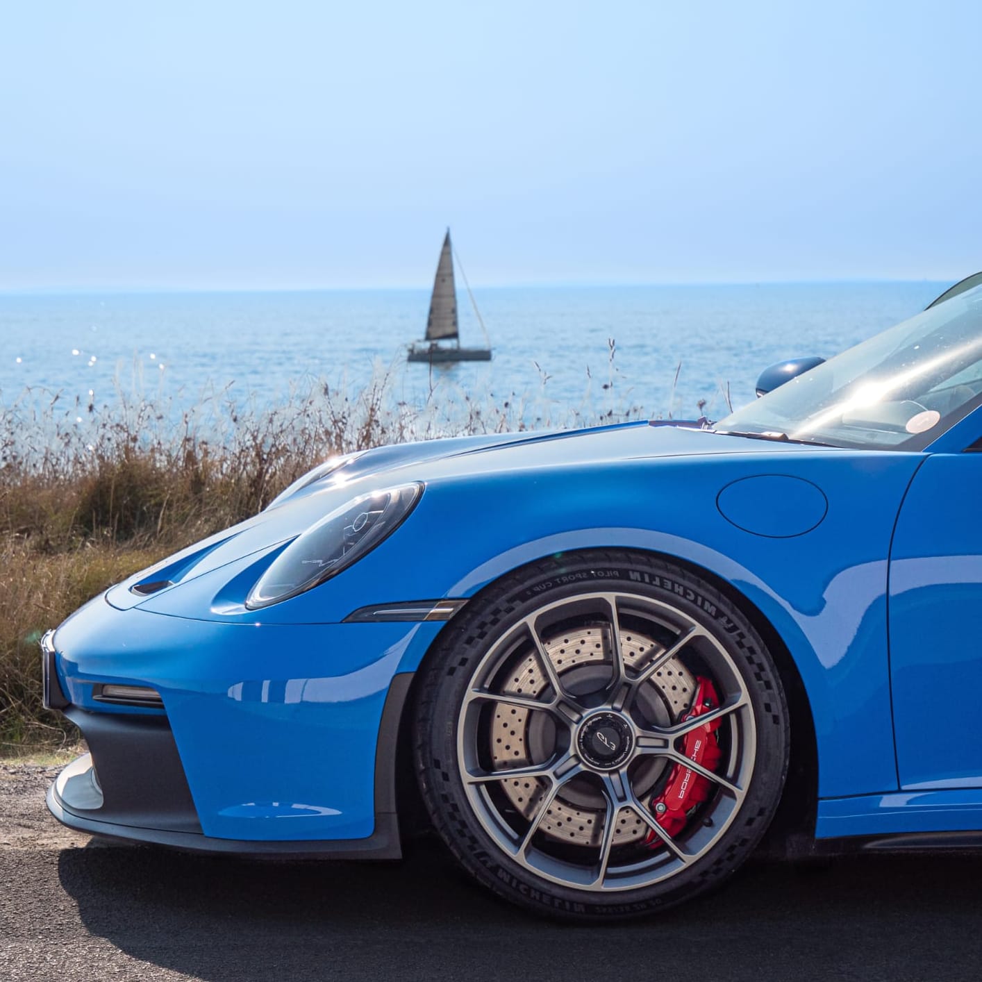 Vue de profil d’une Porsche bleue avec les Centres Porsche RCM