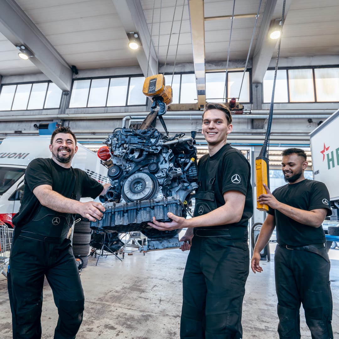 Techniciens SAGA CHUR manipulant un moteur Mercedes-Benz en atelier