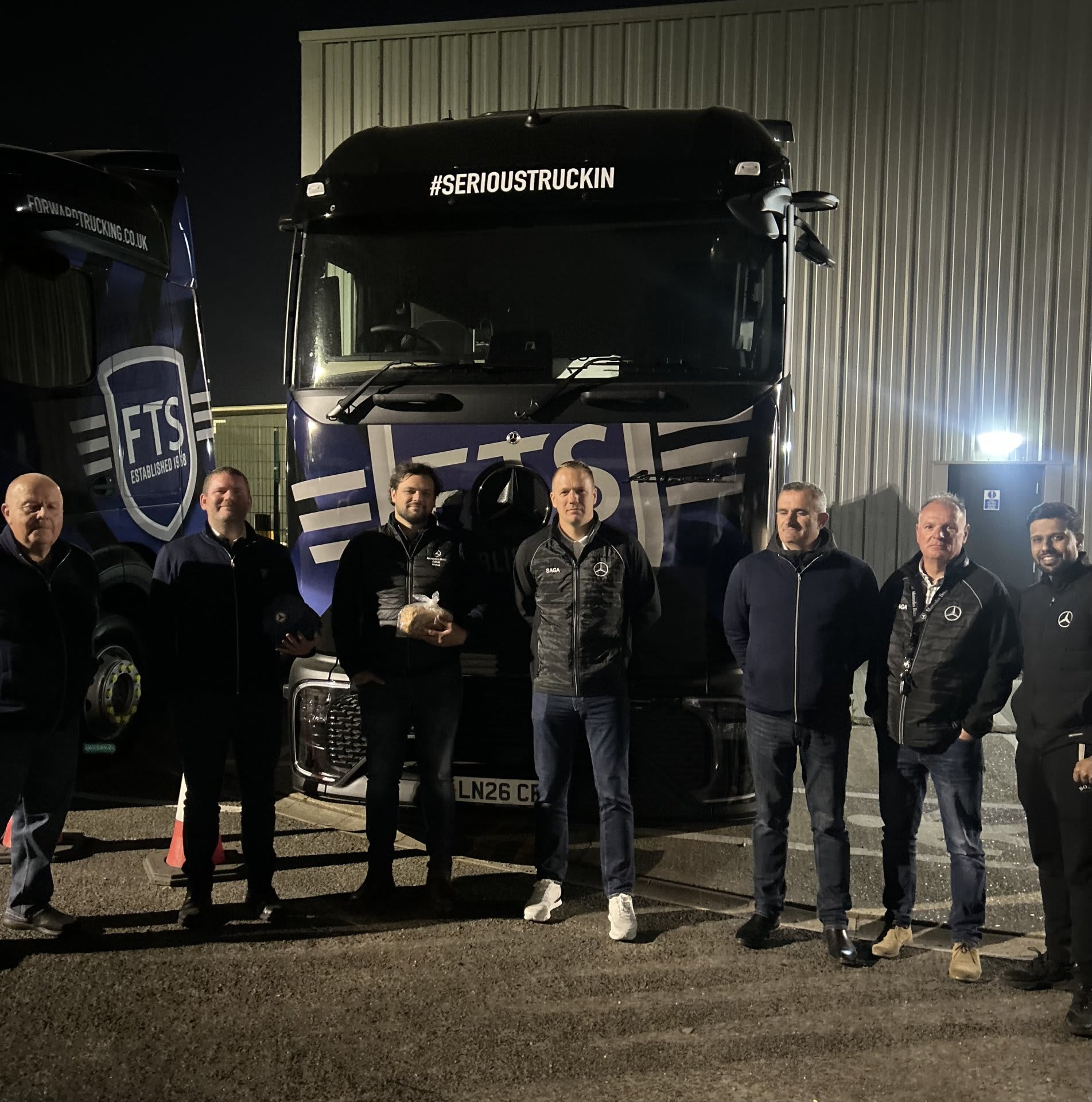 Équipe SAGA Truck & Van devant un camion Mercedes-Benz au Royaume-Uni