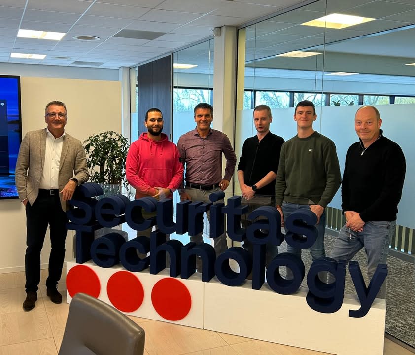 Dani Peper, Stefan Snippe en Vincent van Gennep samen poserend op kantoor in Dordrecht achter het logo van Securitas Technology, nadat ze de overstap maakten van beveiliger naar de techniek.