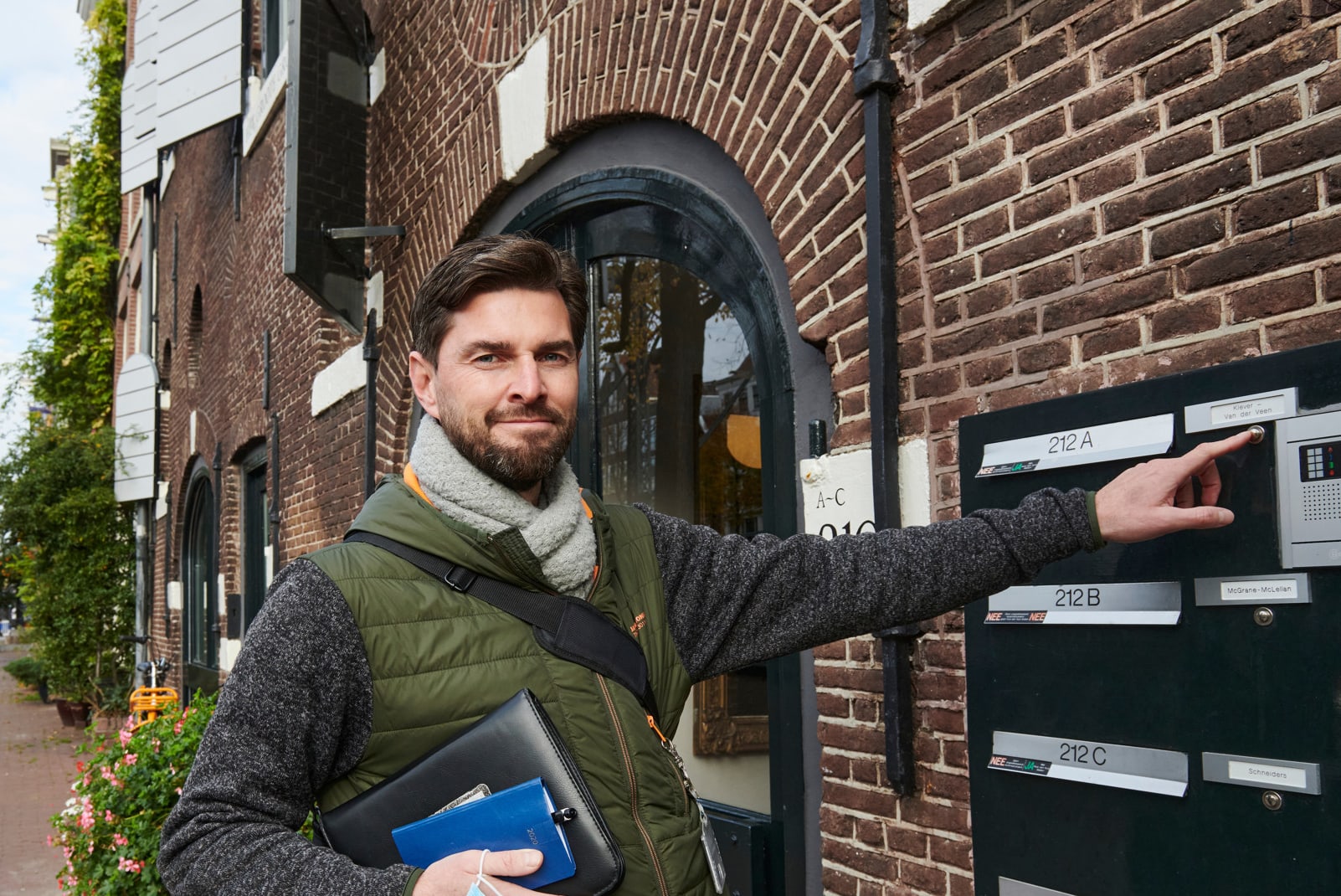 Vrolijke CBS collega belt aan bij een huis voor afnemen interview