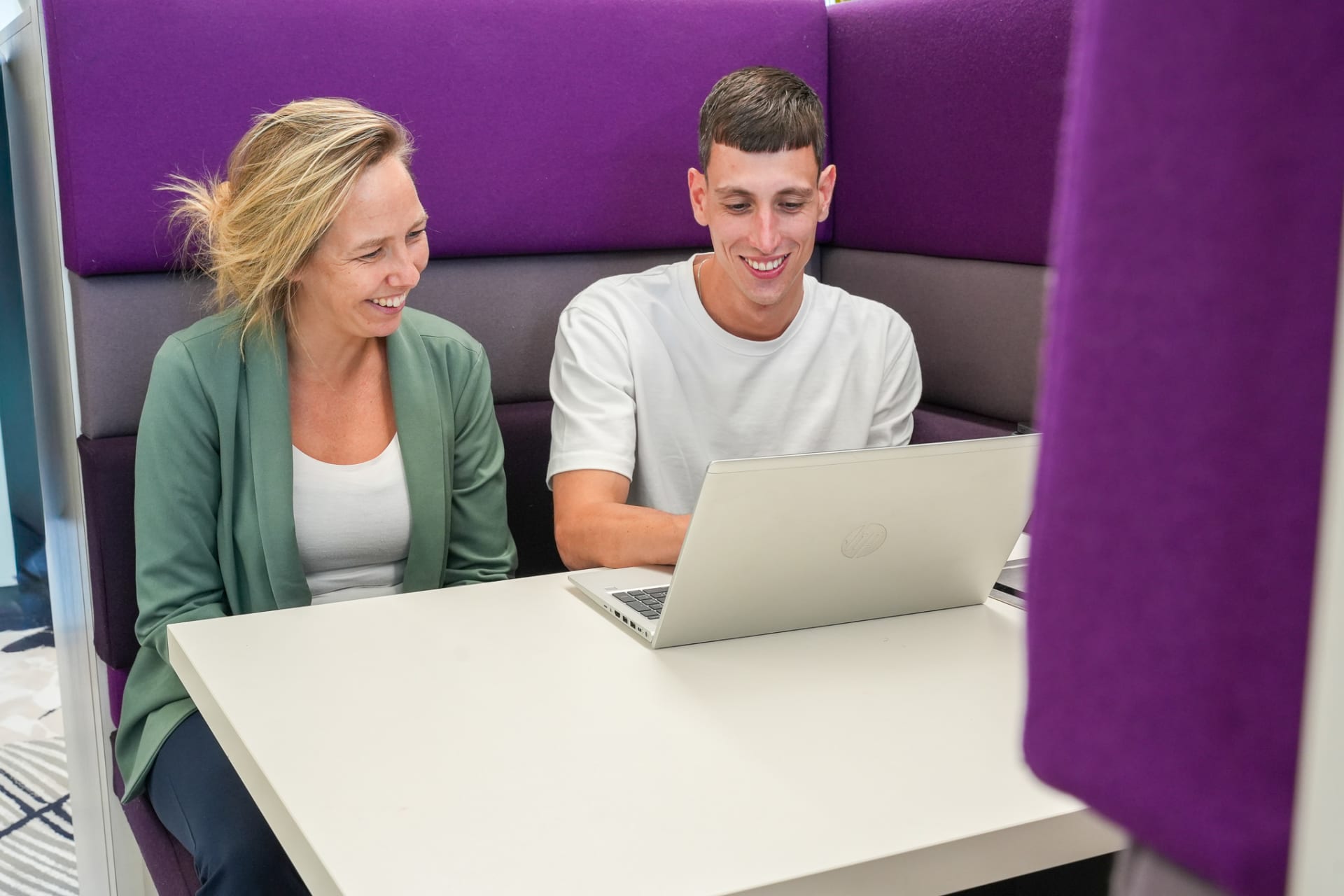 Contractmanager Julien met collega achter een laptop