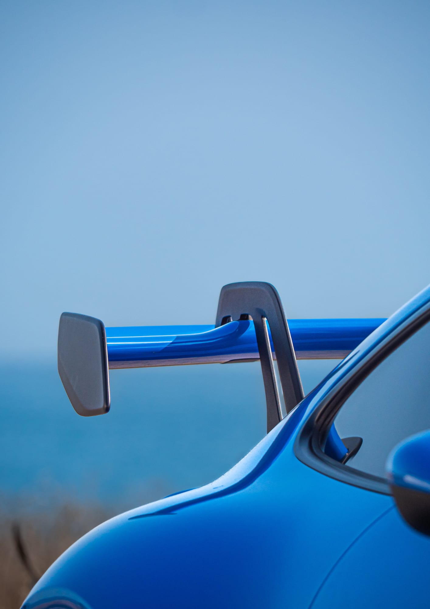 Logo des Centres Porsche Bordeaux, La Rochelle et Bayonne avec détail d’une Porsche bleue