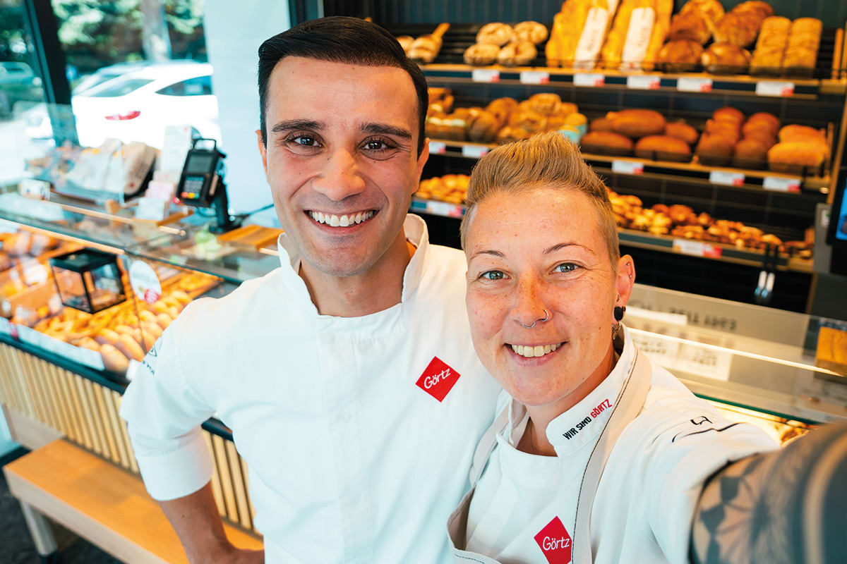 2 Mitarbeitenden Lächeln in die Kamera In einer Bäckerei.