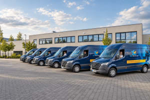 Blaue Servicefahrzeuge vor einem Firmengebäude.